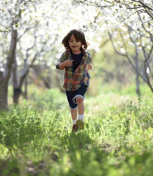 happy boy running through forest